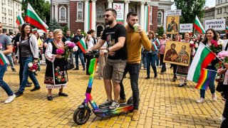 София, жълтите павета. 24-ти май. Чефо и Лефо се поклащат несигурно върху споделена електрическа тротинетка с цветовете на дъгата